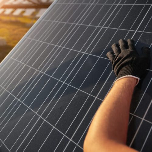 Main posée sur un panneaux solaire