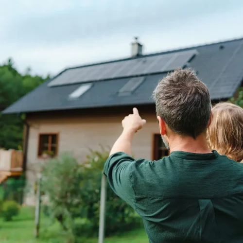 Famille devant une maison avec des panneaux photovoltaique